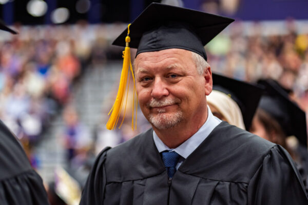 An older male student wears a cap and gown during the WSU Commencement ceremony.