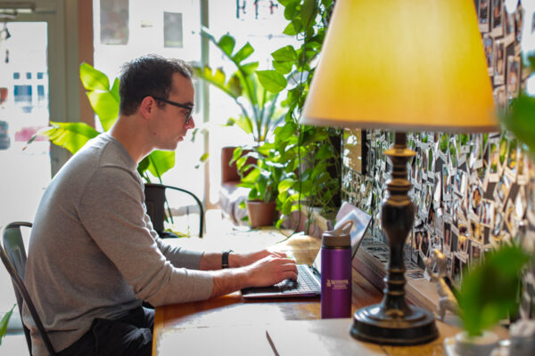 A male WSU student studies at a coffee shop.