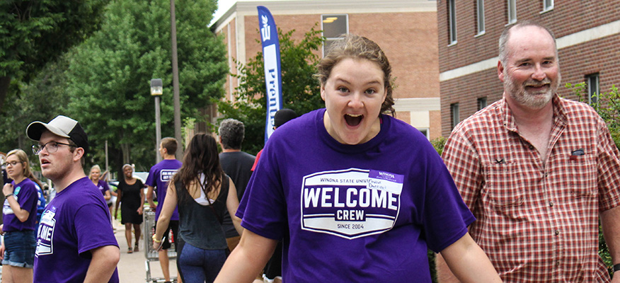 An excited Welcome Crew volunteer greets students moving into the WSU residence halls.