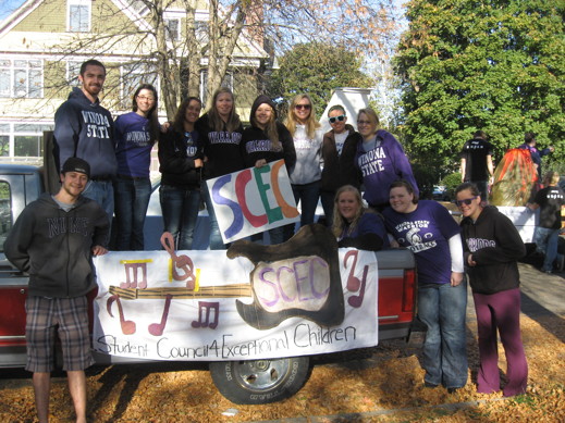 A group of students pose together on a parade float.