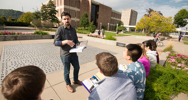 WSU professor discussing a daily topic with students in the courtyard.