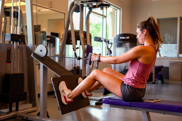 A student works out with weight-lifting equipment in the WSU Fitness Center.