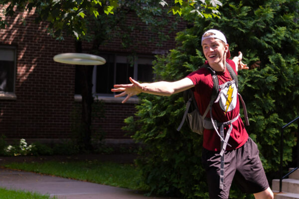 A student tosses a frisbee on WSU campus.