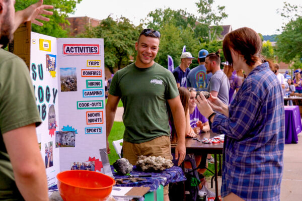 Students talk together at a club table during the fall club fair.