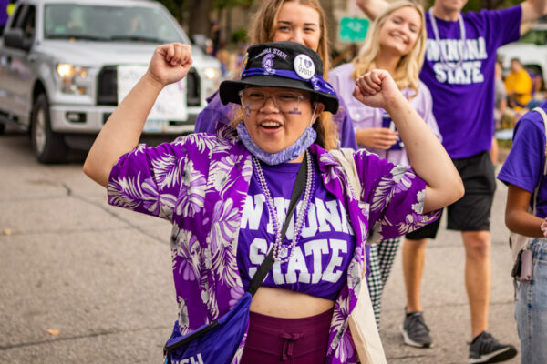 Students dressed in WSU apparel and purple facepaint walk in the Homecoming Parade.