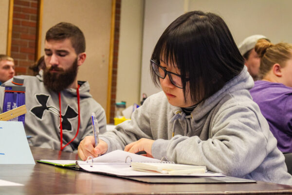 A student writes notes during class.