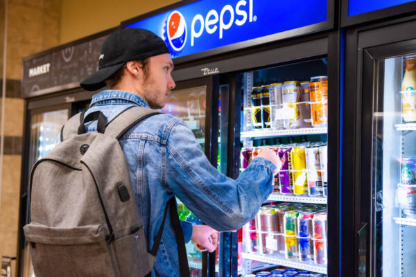 A male student grabs a beverage from a cooler in Zane's Food Court on the Winona campus.