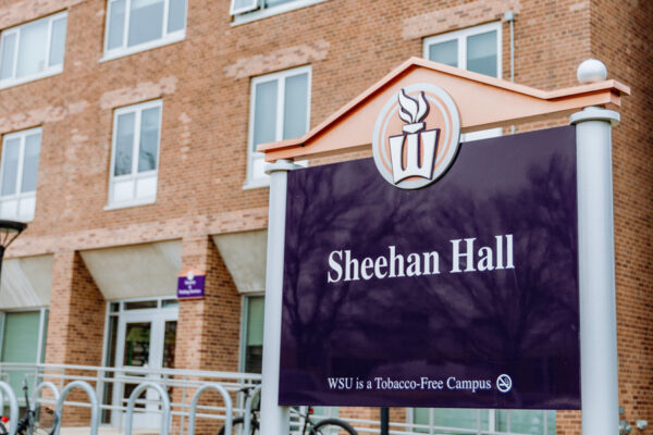 The exterior of the Sheehan Hall with a wayfinding sign on the WSU campus.