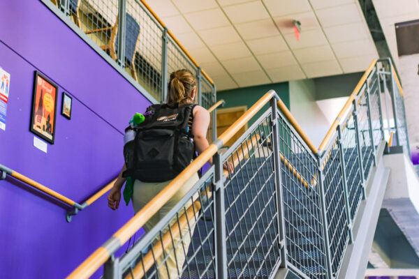 A female student walks upstairs toward the Counseling Services Office on WSU campus.