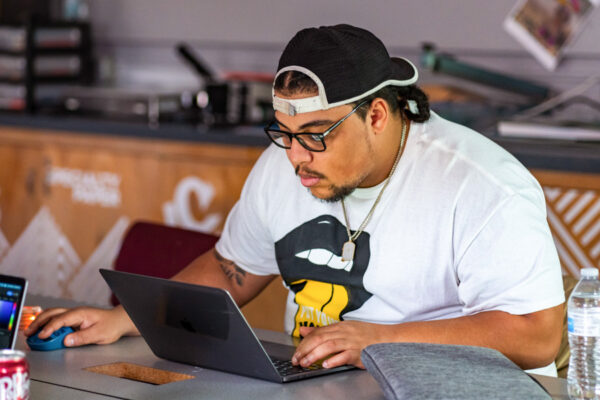 A male student works on a laptop in a classroom on WSU campus.
