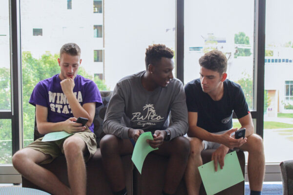 Three male students have a discussion in a lounge on WSU campus.