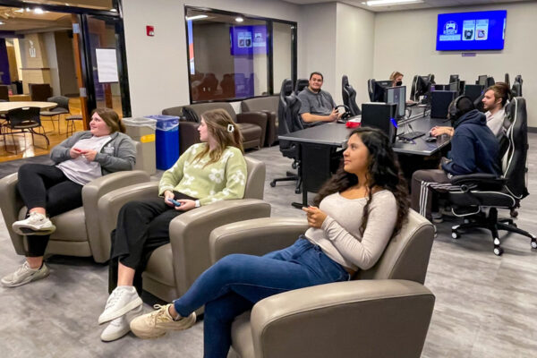 Groups of WSU students play pc and console video games in the Warrior Esports Lounge.