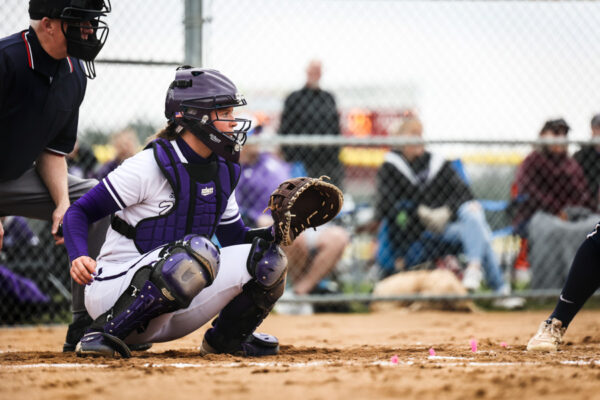 A softball catcher crouches ready at base during a WSU softball game.