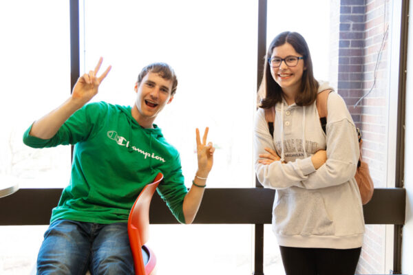 Two students pose smiling on campus.