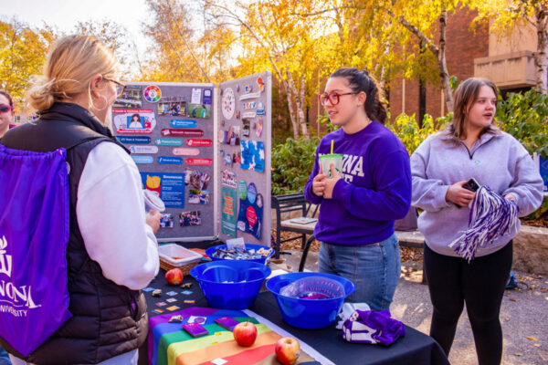Students chat a booth during a club fair on campus.