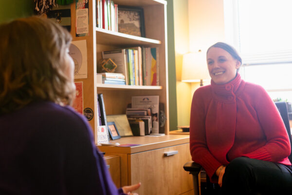 A WSU mental health counselor talks to a student in their office.