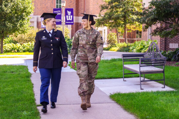 Two students wearing their military uniforms walk across WSU campus together.