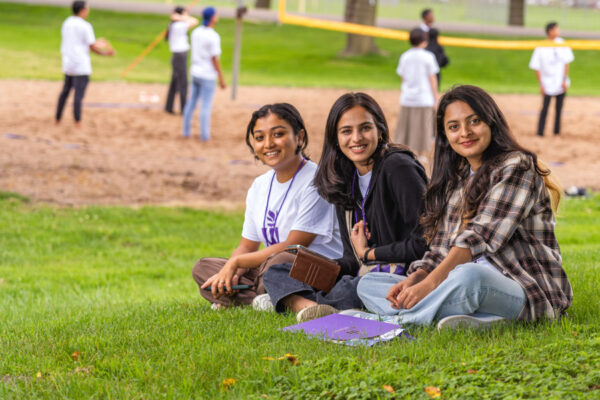 A group of international students relax outside on campus.