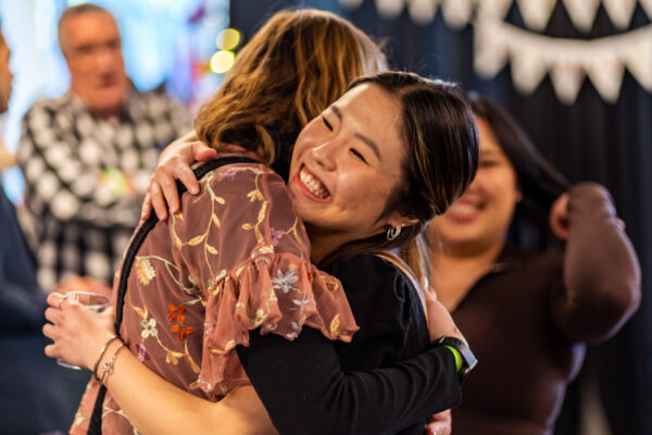 Two people hug at a campus event.