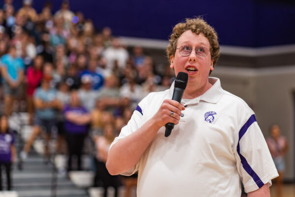 A student gives a speech to a crowd in the McCown Gym.