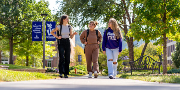 Three students chat while walking through the WSU campus in Winona.