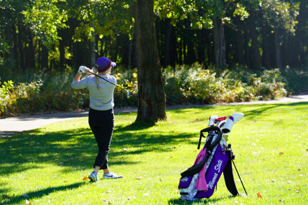 A WSU athlete swings a golf club at a local golf course in Winona.