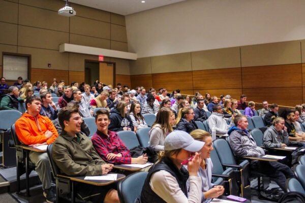 A group of people attend a lecture in an auditorium on the WSU campus.