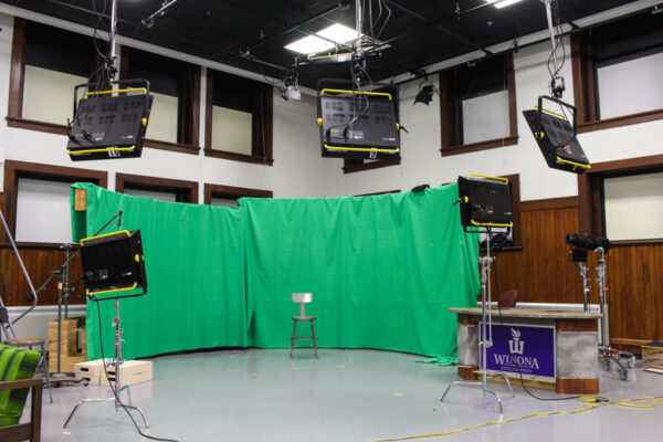 A multimedia studio with a green screen area and film cameras.