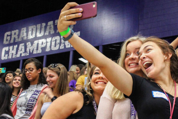 Female students take a selfie in the bleachers at McCown Gym