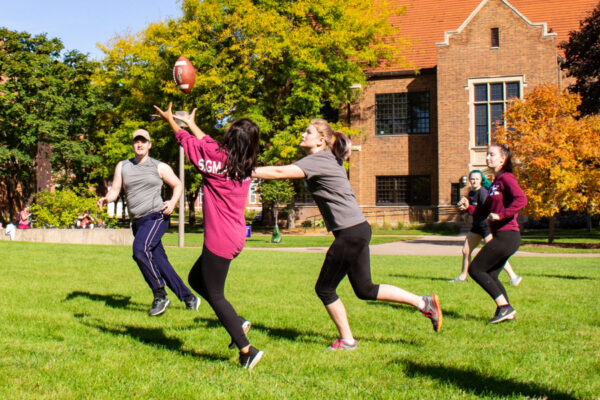Students play a casual game of football on the green at WSU campus.