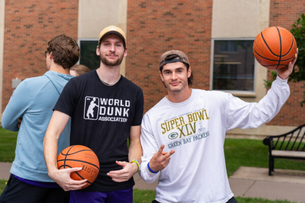 Male students pose together holding basketballs on the WSU campus.