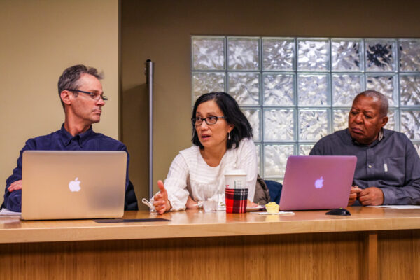 Faculty members discuss issues during a meeting.