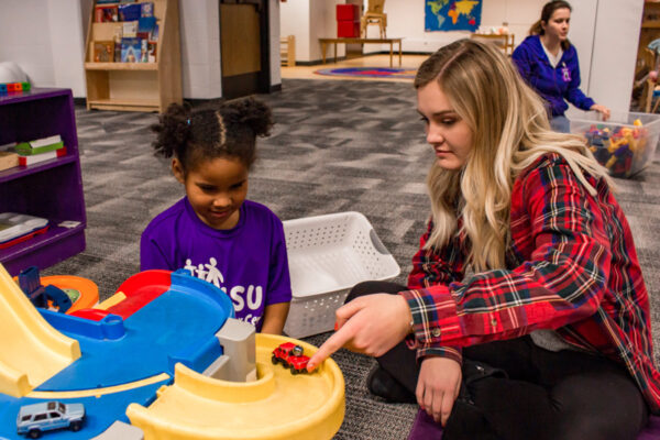 A classroom teacher plays with a kid at the WSU Children's Center.