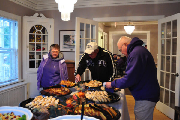 Three retirees enjoy a buffet at an event in the WSU Alumni House.