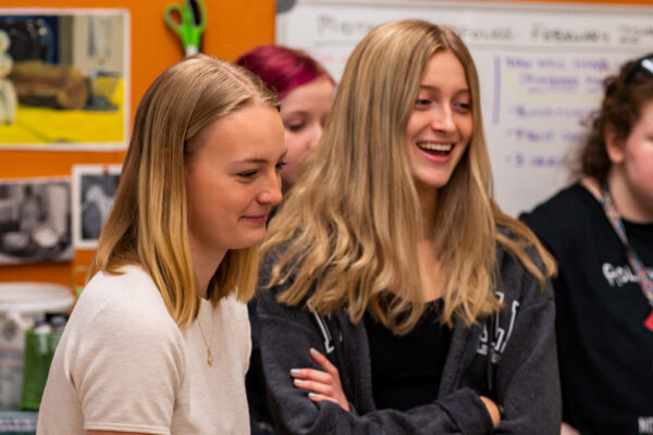A group of female students laugh together.