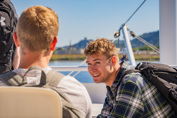 Two students have a conversation on the deck of the Cal Fremling boat.