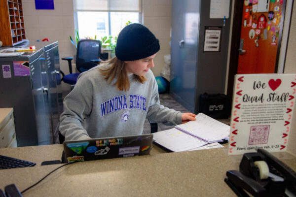 A student worker sits at the front desk in Conway Hall.