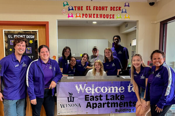 Student workers pose around the front desk in East Lake Apartments.