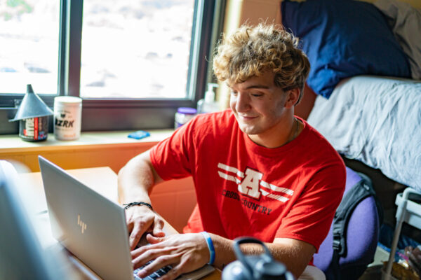 A student works on a laptop at a desk in a room in Kirkland-Haake Hall.