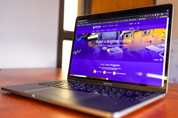 A laptop displays the WSU website.
