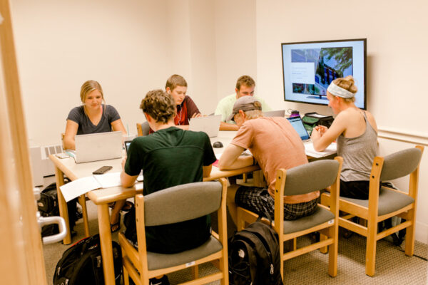 A group of students work together on a project in a study room in the WSU Library.