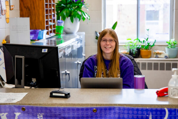 A student worker sits at the front desk in Morey-Shepard Hall.