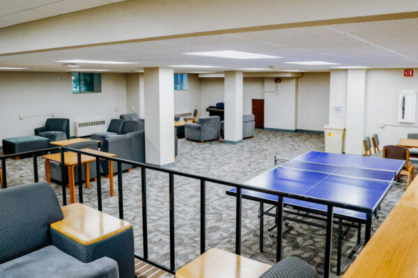 A lounge with many tables, chairs, couches, and a ping-pong table in Morey-Shepard Hall.