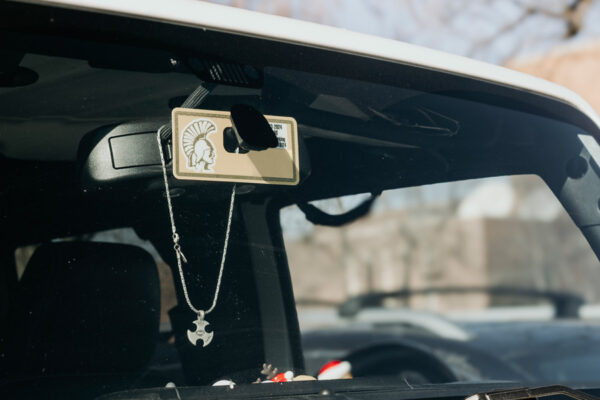 A WSU parking permit hangs from the rear-view mirror in a car.