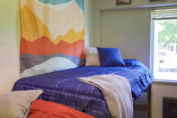 A decorated room with a lofted bed by the windows in Prentiss-Lucas Hall.
