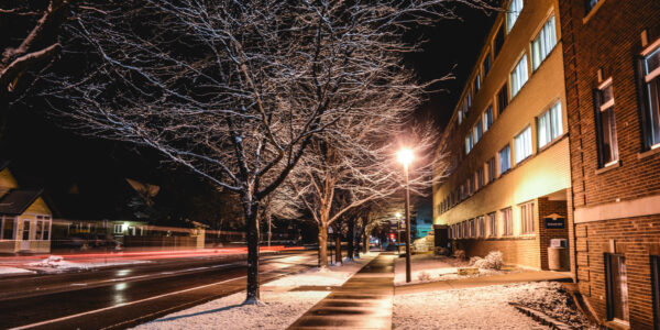 A view of the exterior of Richards Hall along Huff St. in Winona, MN on a winter night.