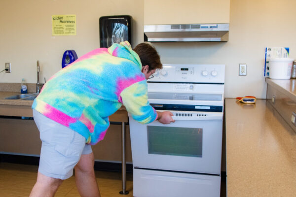 A student opens an oven in a kitchen in Richards Hall.