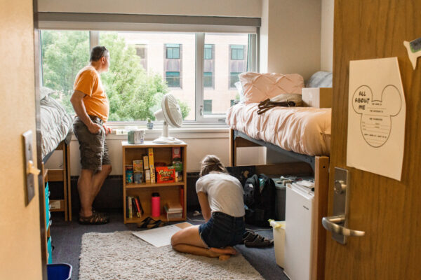 A parent helps a student set up their room in Sheehan Hall.