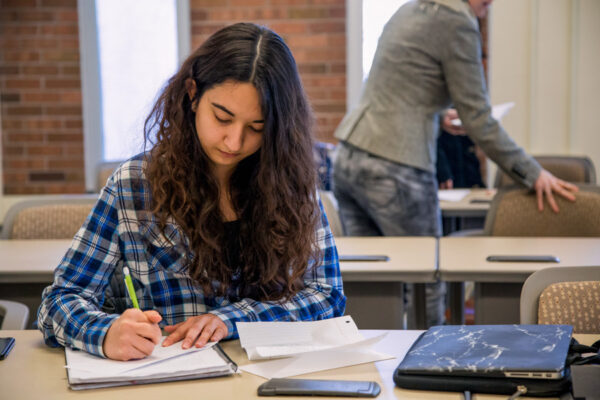 A student takes notes during class on the WSU campus.