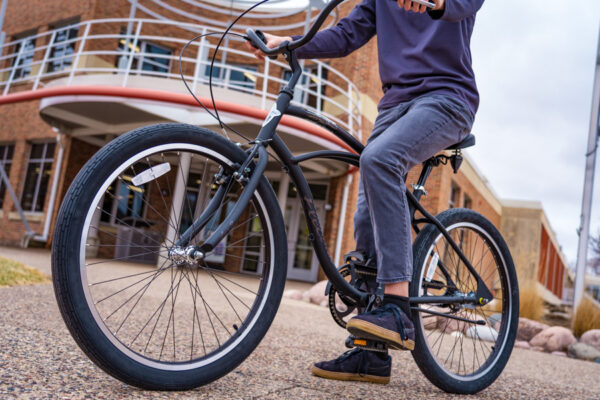 A student poses with a bike in front of Kryzsko Commons on the WSU campus.